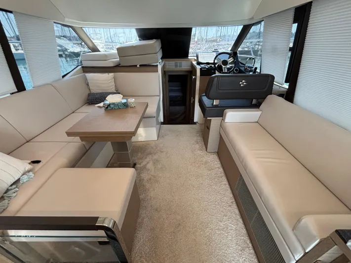  Yacht Photos Pics Luxurious interior of 2020 Jeanneau Prestige 420 Flybridge yacht with beige seating and helm.