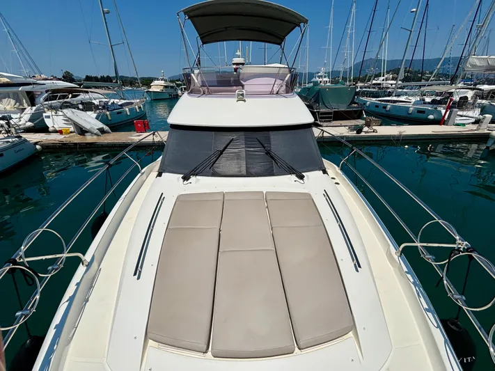  Yacht Photos Pics 2020 Jeanneau Prestige 420 Flybridge yacht docked in marina, featuring spacious sunbathing area.