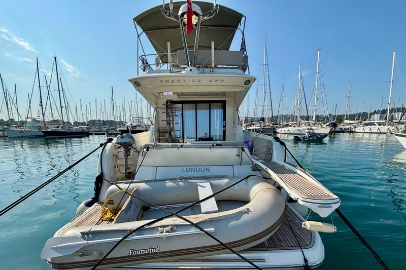  Yacht Photos Pics Jeanneau Prestige 420 Flybridge 2020 yacht docked in a marina with inflatable boat.