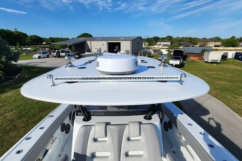 Arrogant 1 Yacht Photos Pics 2022 Freeman 37 Center Console boat with advanced radar and seating, parked outdoors.