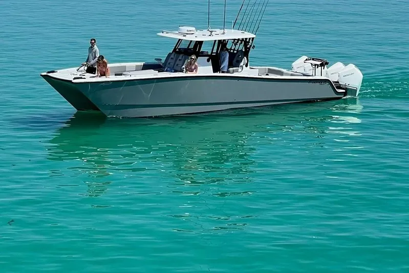 Arrogant 1 Yacht Photos Pics 2022 Freeman 37 Center Console boat on clear turquoise water.