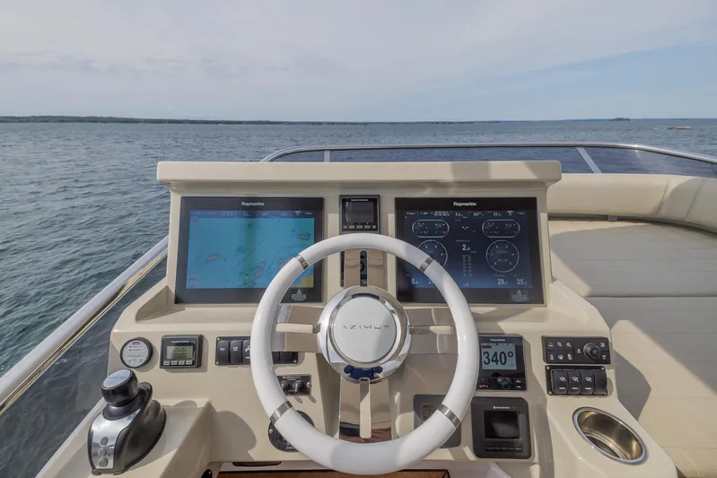  Yacht Photos Pics Helm of 2018 Azimut 50 Flybridge yacht with navigation screens and steering wheel.