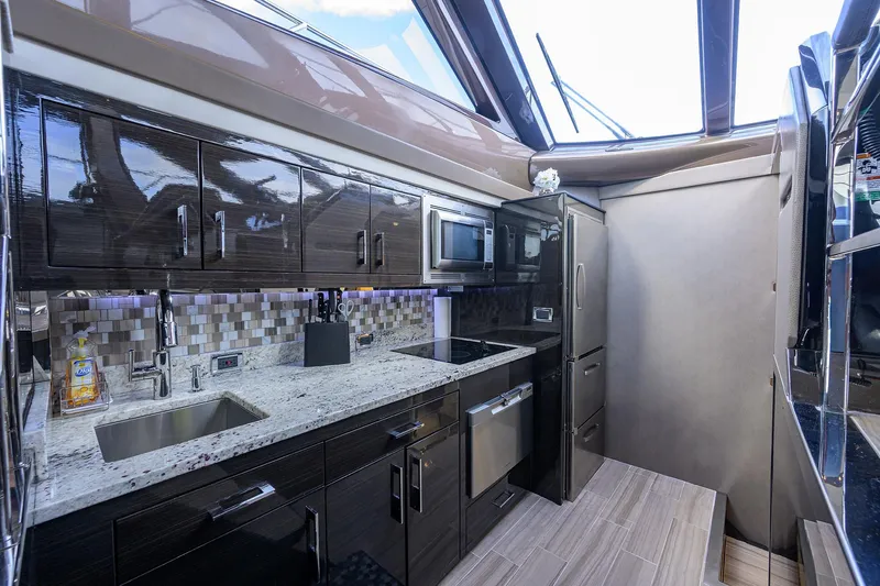 Andiamo Yacht Photos Pics Luxurious kitchen interior of 2016 Marquis 660 Sport Yacht with modern appliances and sleek design.