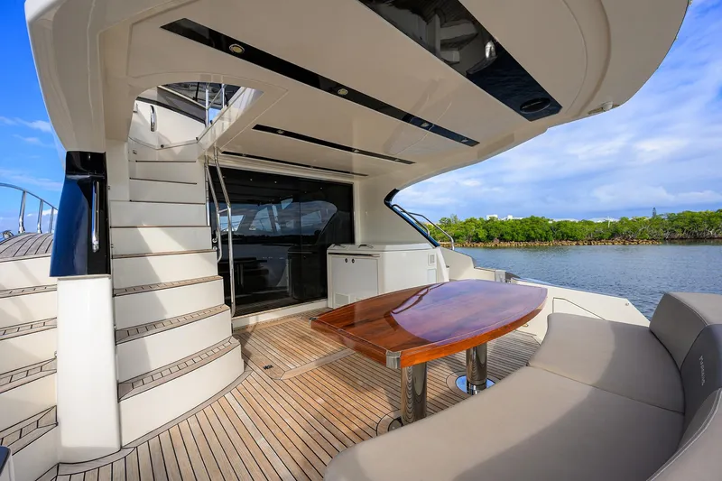 Andiamo Yacht Photos Pics Luxurious 2016 Marquis 660 Sport Yacht deck with elegant seating and scenic water view.