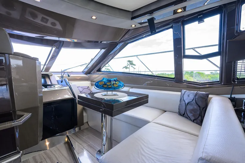 Andiamo Yacht Photos Pics Luxurious interior of 2016 Marquis 660 Sport Yacht with modern seating and panoramic windows.