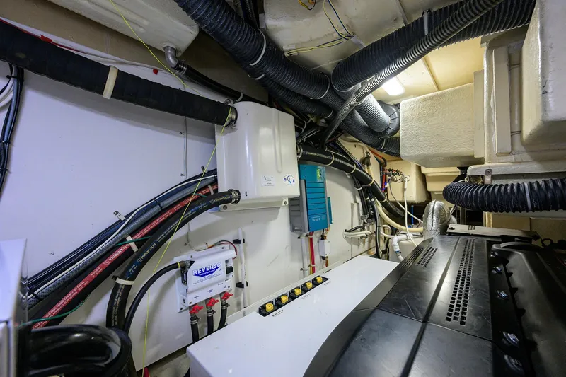 Andiamo Yacht Photos Pics Engine room of 2016 Marquis 660 Sport Yacht with visible wiring and equipment.