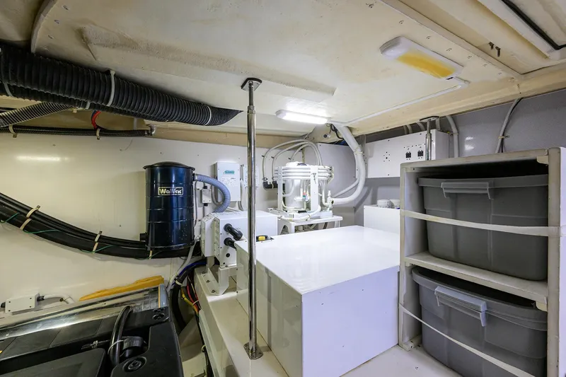 Andiamo Yacht Photos Pics Engine room of 2016 Marquis 660 Sport Yacht with storage bins and equipment.