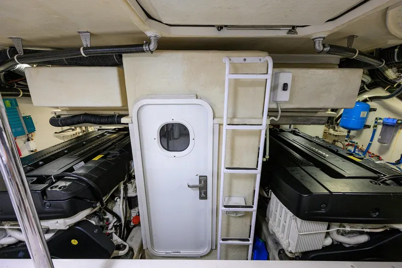 Andiamo Yacht Photos Pics Engine room of 2016 Marquis 660 Sport Yacht with dual engines and access door.