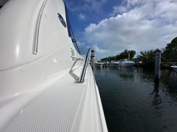 Off Duty Yacht Photos Pics 2004 Sea Ray 360 Sundancer docked, side view with clear sky and water.
