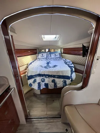 Off Duty Yacht Photos Pics 2004 Sea Ray 360 Sundancer cabin with bed, nautical-themed bedding, and wood accents.