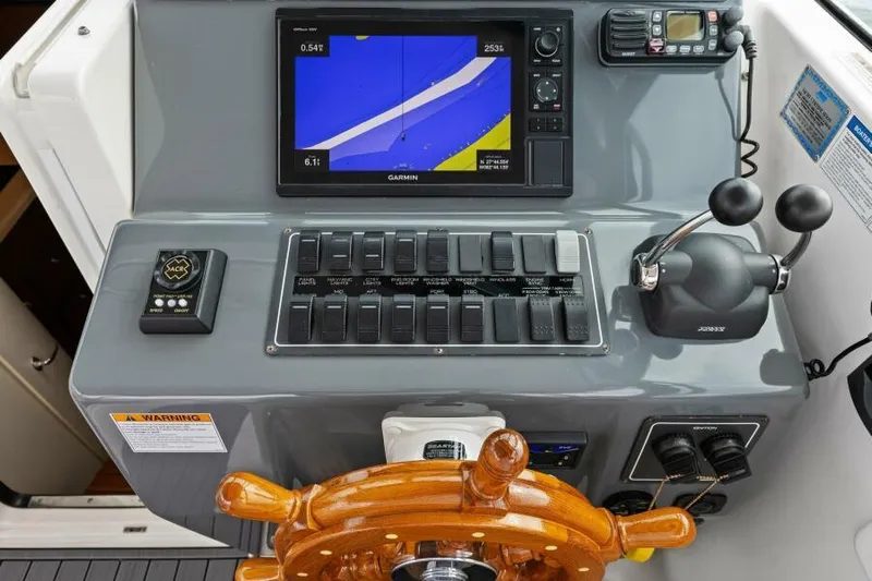 Indeed Yacht Photos Pics Tiara Yachts 2900 Open 2005 helm with navigation controls and wooden steering wheel.