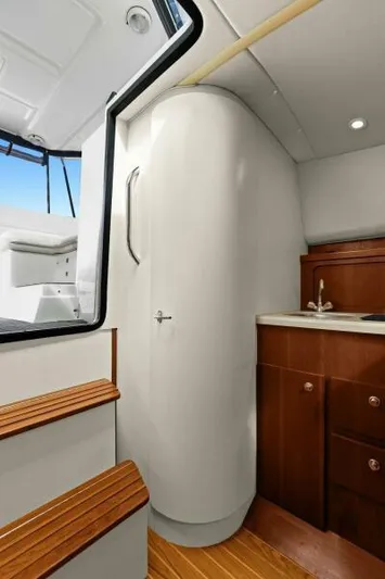 Indeed Yacht Photos Pics 2005 Tiara Yachts 2900 Open interior with wooden cabinetry and compact bathroom.