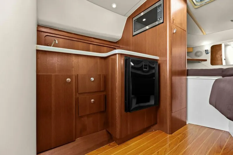 Indeed Yacht Photos Pics 2005 Tiara Yachts 2900 Open cabin interior with wood cabinetry and compact kitchen area.