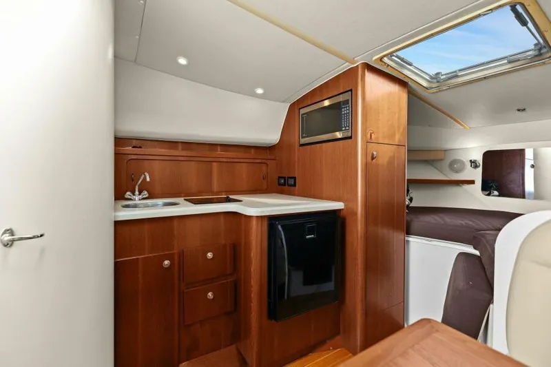 Indeed Yacht Photos Pics 2005 Tiara Yachts 2900 Open interior with kitchenette and cozy cabin space.