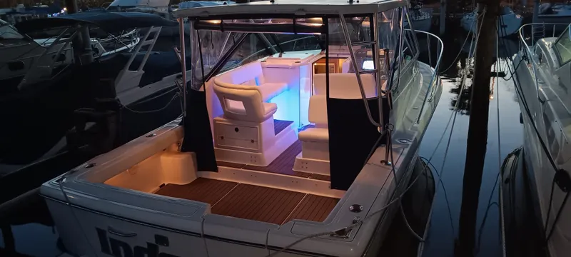 Indeed Yacht Photos Pics 2005 Tiara Yachts 2900 Open with illuminated interior, docked at sunset.