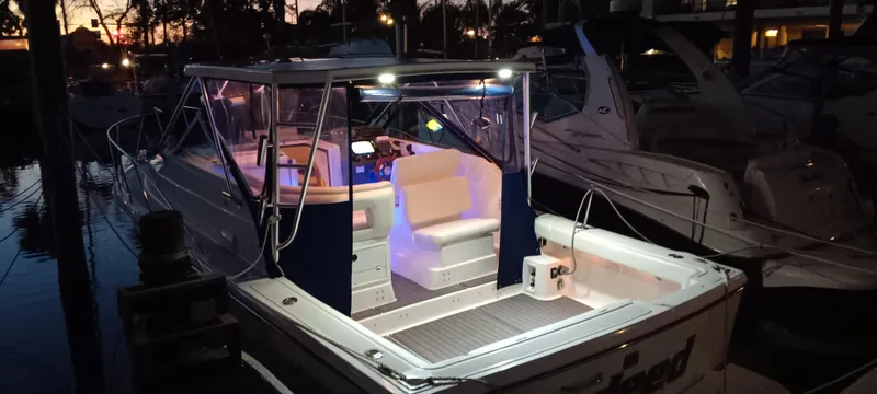 Indeed Yacht Photos Pics 2005 Tiara Yachts 2900 Open at dusk, illuminated interior, docked in marina.