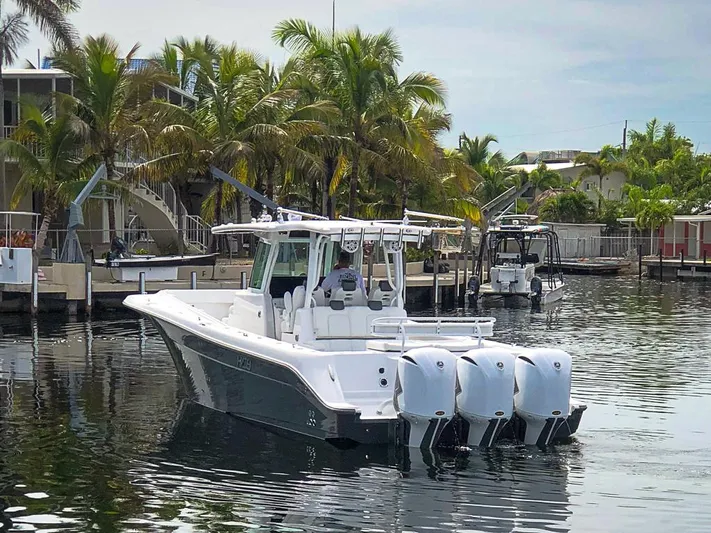  Yacht Photos Pics 2019 HCB 39 Speciale boat with triple engines docked near palm trees.