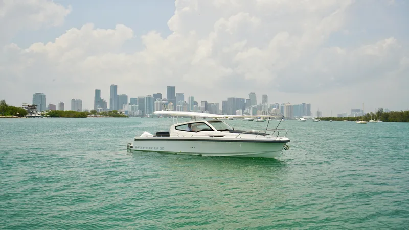 In-stock 2024 Nimbus W9 #279 Yacht Photos Pics Nimbus Weekender 9 #279 (2024) boat on water with city skyline background.