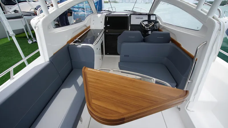 In-stock 2024 Nimbus W9 #279 Yacht Photos Pics Interior of 2024 Nimbus Weekender 9 #279 boat with seating and wooden table.