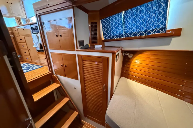 Revere Yacht Photos Pics Interior of 2002 Grand Banks 42 Classic yacht with wooden cabinetry and blue curtains.