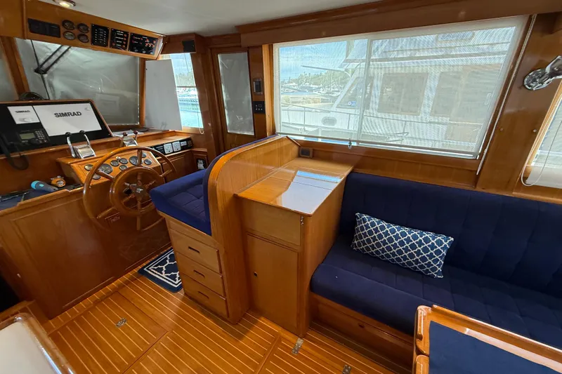 Revere Yacht Photos Pics Interior of 2002 Grand Banks 42 Classic yacht with wooden helm and blue seating.
