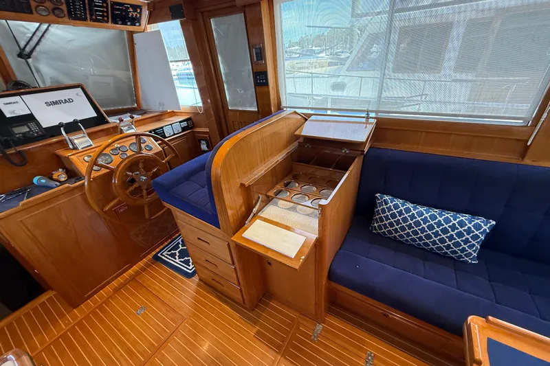 Revere Yacht Photos Pics Interior of 2002 Grand Banks 42 Classic yacht with wooden helm and blue seating.