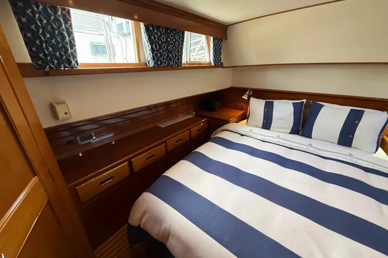 Revere Yacht Photos Pics Cozy bedroom in 2002 Grand Banks 42 Classic yacht with striped bedding and wooden cabinetry.