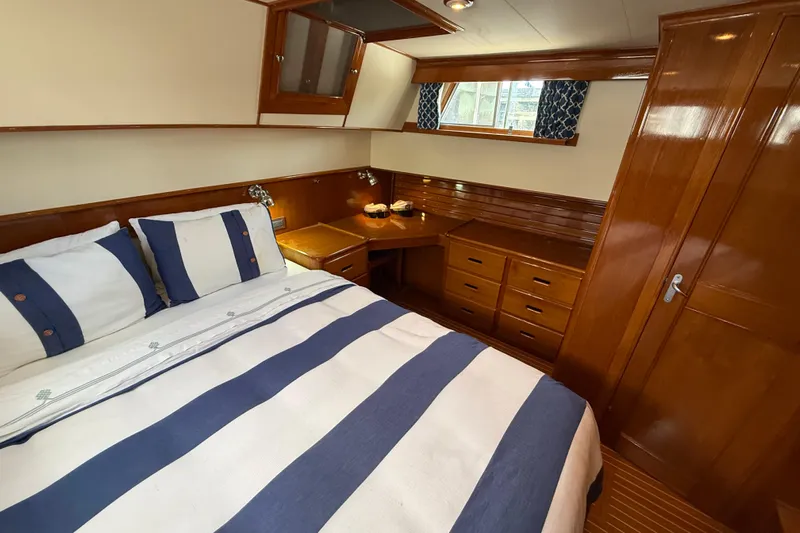 Revere Yacht Photos Pics Luxurious cabin interior of 2002 Grand Banks 42 Classic yacht with wood finish and striped bedding.