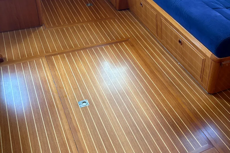Revere Yacht Photos Pics Teak flooring and blue cushioned seating in 2002 Grand Banks 42 Classic yacht interior.
