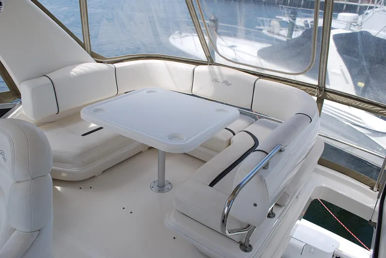  Yacht Photos Pics 2004 Sea Ray Sedan Bridge interior with white seating and table, overlooking water.