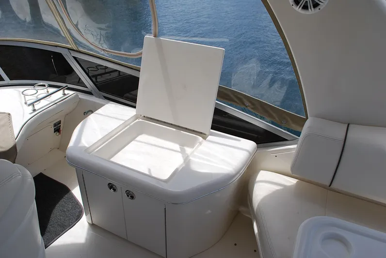  Yacht Photos Pics 2004 Sea Ray Sedan Bridge interior with open storage compartment, overlooking water.