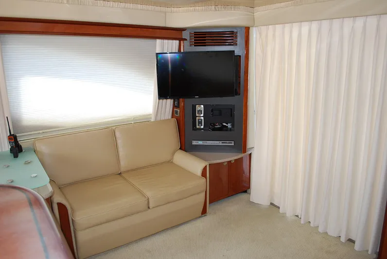  Yacht Photos Pics 2004 Sea Ray Sedan Bridge interior with beige sofa, TV, and curtains.