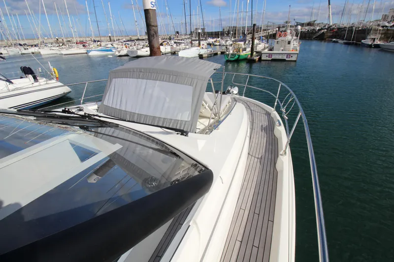  Yacht Photos Pics 2025 Prestige 520 yacht docked in a marina, showcasing sleek design and spacious deck.