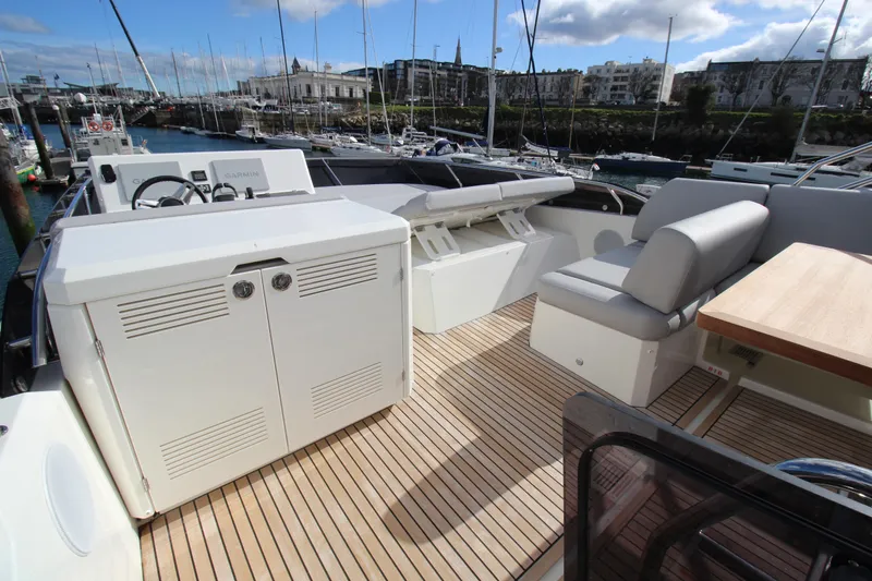  Yacht Photos Pics Prestige 520 yacht deck, 2025 model, featuring seating and storage, docked in a marina.