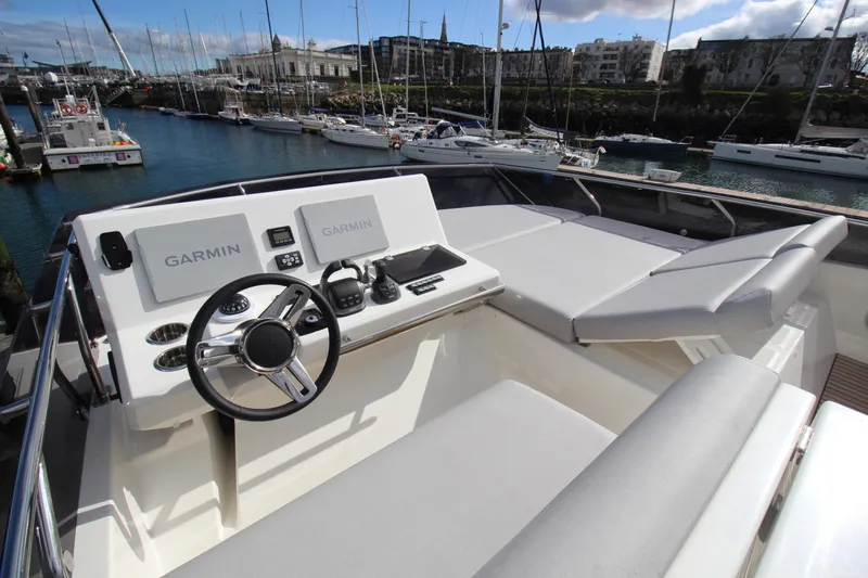 Yacht Photos Pics Luxurious 2025 Prestige 520 yacht helm with Garmin navigation, docked in a marina.