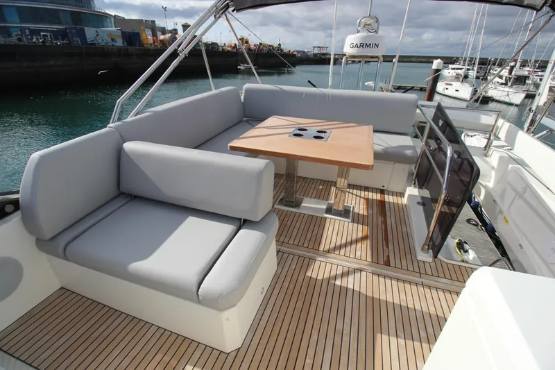  Yacht Photos Pics Luxury seating area on 2025 Prestige 520 yacht with wooden deck and table.