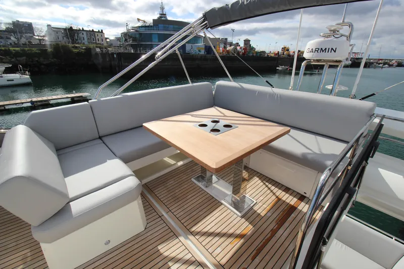  Yacht Photos Pics Luxury seating area on 2025 Prestige 520 yacht with wooden table and waterfront view.