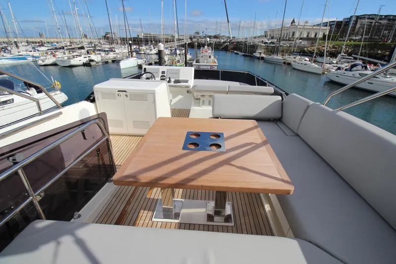  Yacht Photos Pics Luxurious Prestige 520 yacht deck with seating and table, docked in a marina, 2025 model.