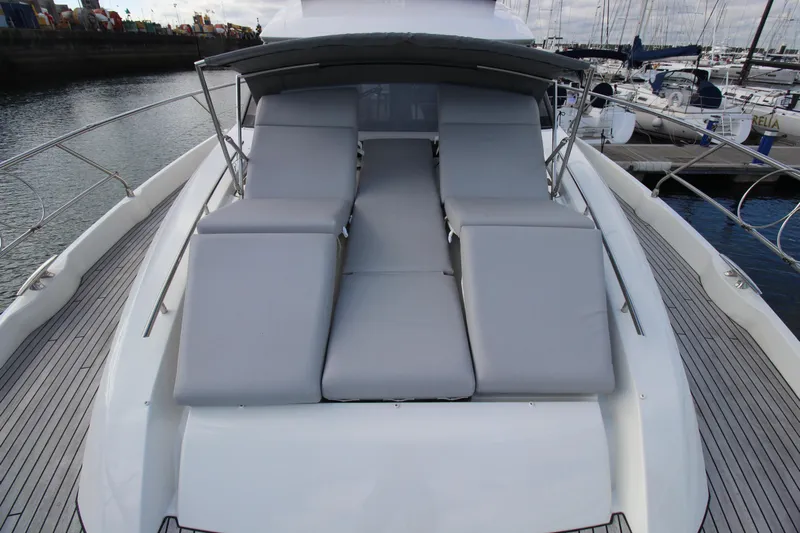  Yacht Photos Pics Luxury sunbathing area on 2025 Prestige 520 yacht, featuring comfortable gray cushions.