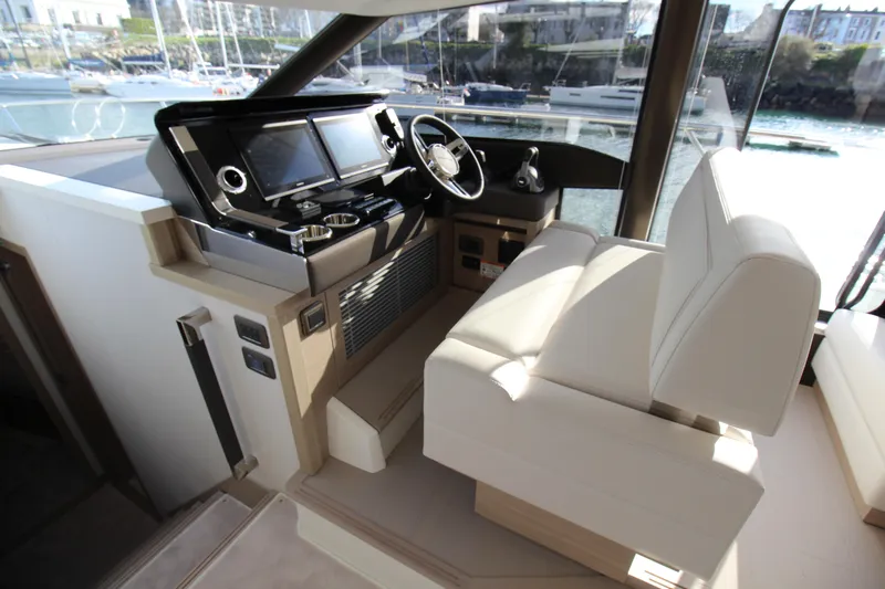  Yacht Photos Pics Luxurious interior of 2025 Prestige 520 yacht with modern helm and plush seating.