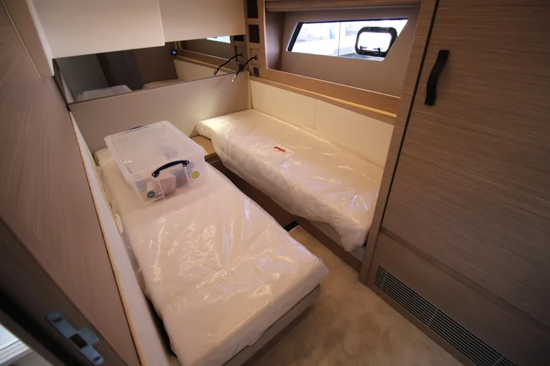  Yacht Photos Pics Twin beds in a 2025 Prestige 520 yacht cabin, featuring modern design and natural lighting.