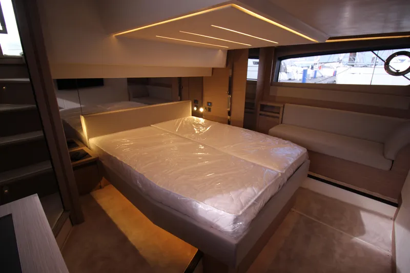  Yacht Photos Pics Luxurious interior of 2025 Prestige 520 yacht featuring a spacious bedroom with modern lighting.