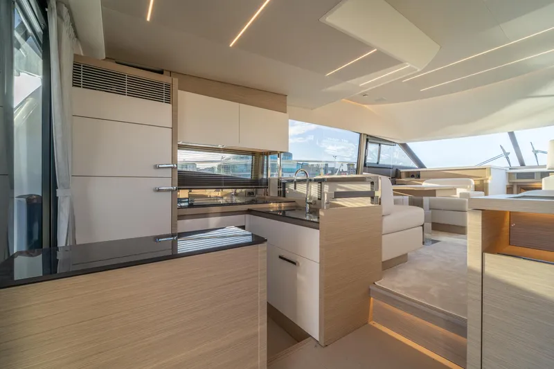  Yacht Photos Pics Luxurious interior of 2025 Prestige 520 yacht with modern kitchen and seating area.