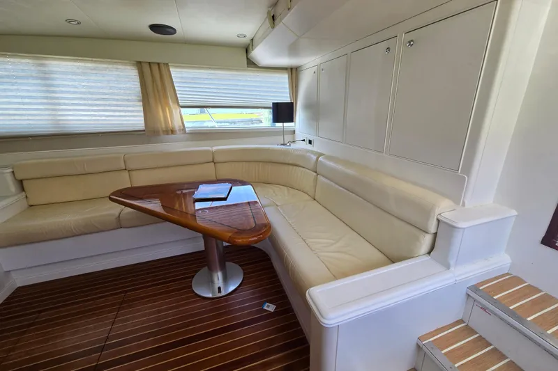 Lady Elizabeth Yacht Photos Pics Luxurious interior of 2006 Huckins Atlantic 44 yacht with cream leather seating and wooden table.