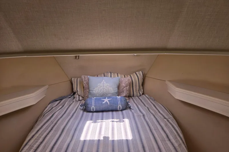 Lady Elizabeth Yacht Photos Pics Cozy cabin interior of 2006 Huckins Atlantic 44 with striped bedding and decorative pillows.