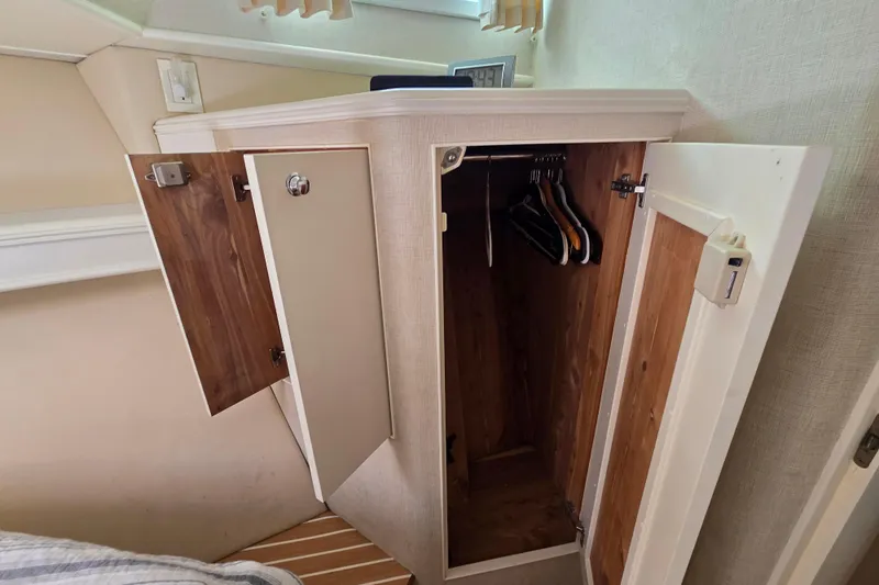 Lady Elizabeth Yacht Photos Pics Open wooden closet with hangers inside, aboard a 2006 Huckins Atlantic 44 yacht.