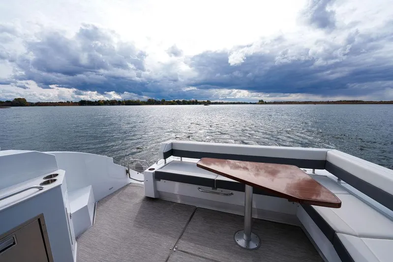  Yacht Photos Pics 2023 Cruisers Yachts 46 Cantius deck with scenic water view and cloudy sky.