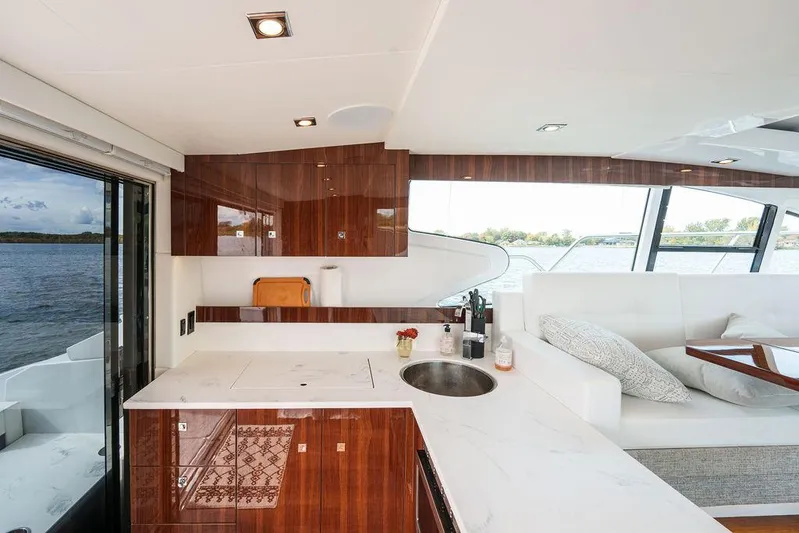  Yacht Photos Pics Luxurious interior of 2023 Cruisers Yachts 46 Cantius with modern kitchen and seating area.