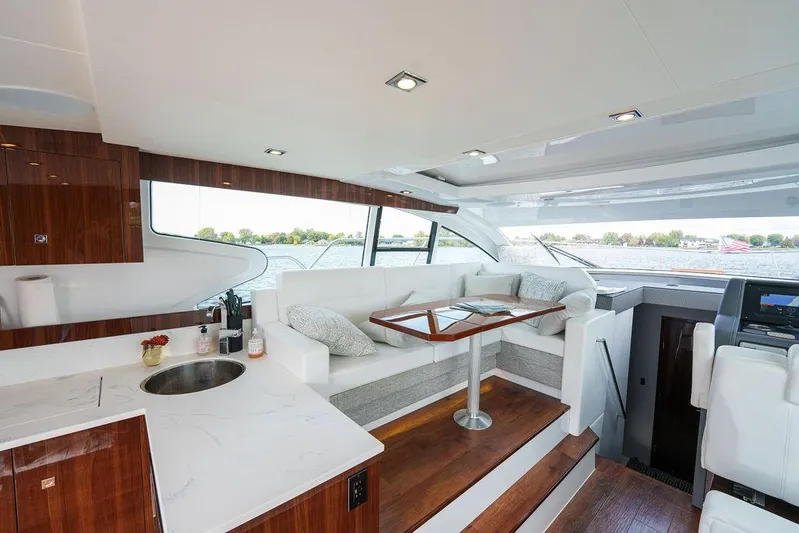  Yacht Photos Pics 2023 Cruisers Yachts 46 Cantius interior with modern seating, table, and kitchenette.