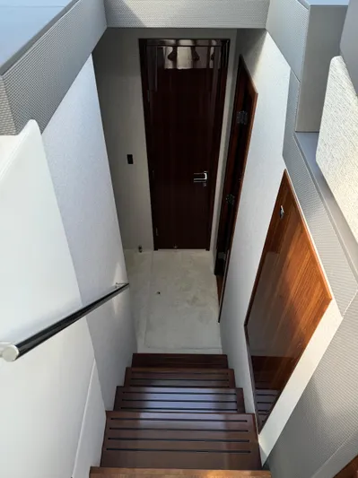  Yacht Photos Pics Staircase inside 2023 Cruisers Yachts 46 Cantius, featuring sleek wooden steps and modern design.